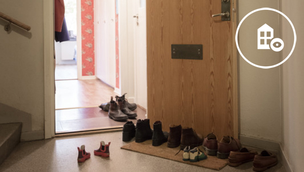 En öppen dörr och många par skor utanför.